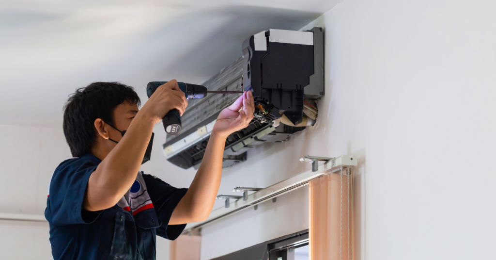 Image of a North Bay Heating and Cooling worker performing a repair in a home.